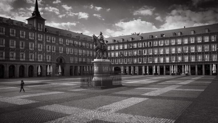 Una persona creua la solitÃ ria Plaza Mayor de Madrid el primer dia del confinament.