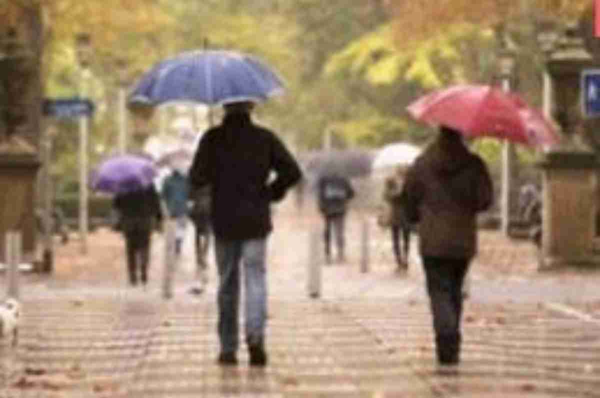 Imatge de dues persones passejant un dia de pluja de tardor