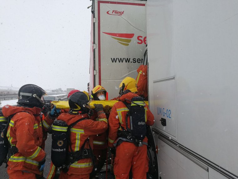 Els bombers excarceren al conductor d'un dels dos camions afectats