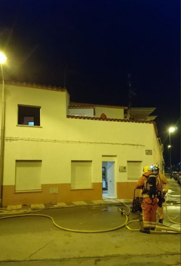 Els bombers apagant l'incendi en l'habitatge de la platja d'Oliva