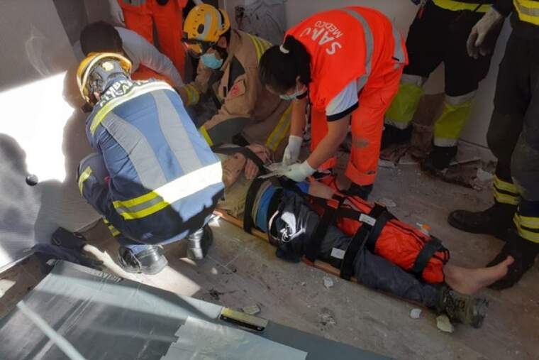 Bomber i personal mèdic ajudant a la víctima d'una caiguda