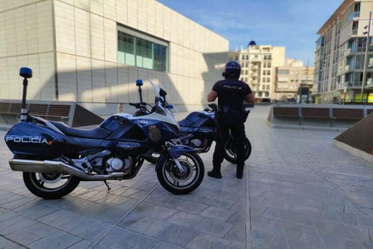 Un policia nacional al costat de dos motos