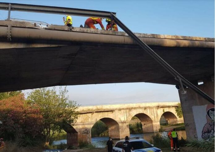 Bombers treballant per a agafar el cos d'un home que ha caigut per un pont