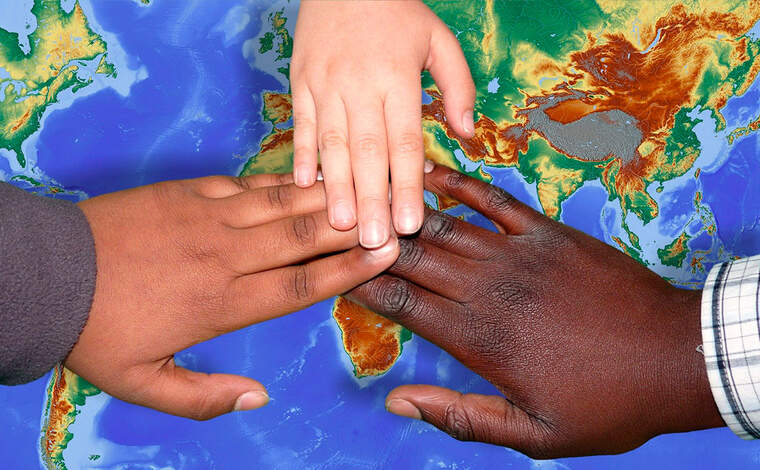 Tres mans de diferents xiquets damunt d'un mapa mundi