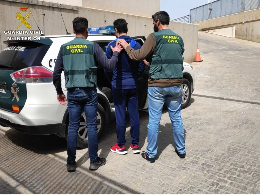 Dos Guàrdia Civils introduint a un detingut en un vehicle oficial.