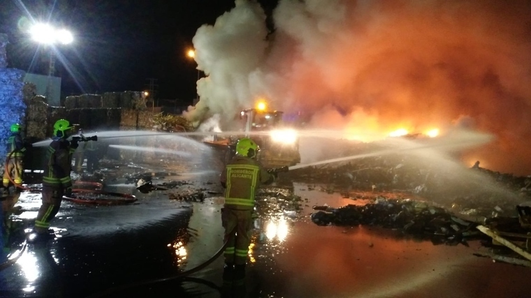 Els bombers tractant d'extingir l'incendi en el polígon de les Talaies