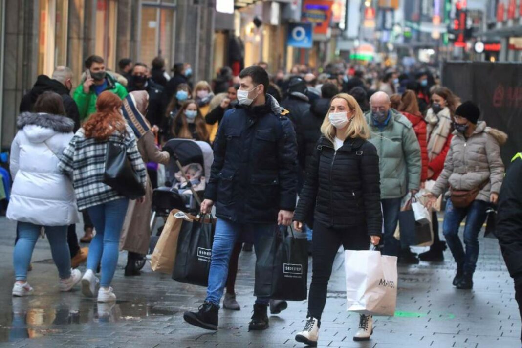 Gent de compres pel carrer amb mascareta