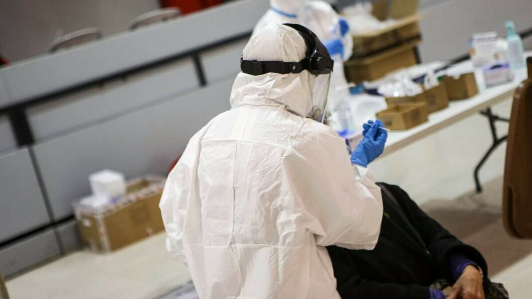 Un professional sanitari fent una prova PCR a una dona durant el cribratge massiu a Montblanc