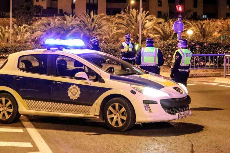 Tres components de la policia local d'Alacant al voltant d'un cotxe