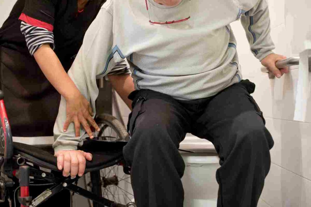 Imatge d'un treballador social d'Aspid ajudant una persona amb discapacitat física