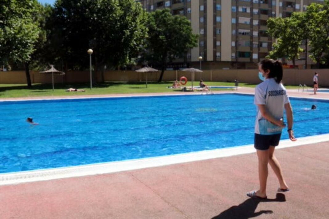 Pla obert de les piscines de Cappont de Lleida amb una socorrista supervisant els banyistes, el 24 de juny del 2021