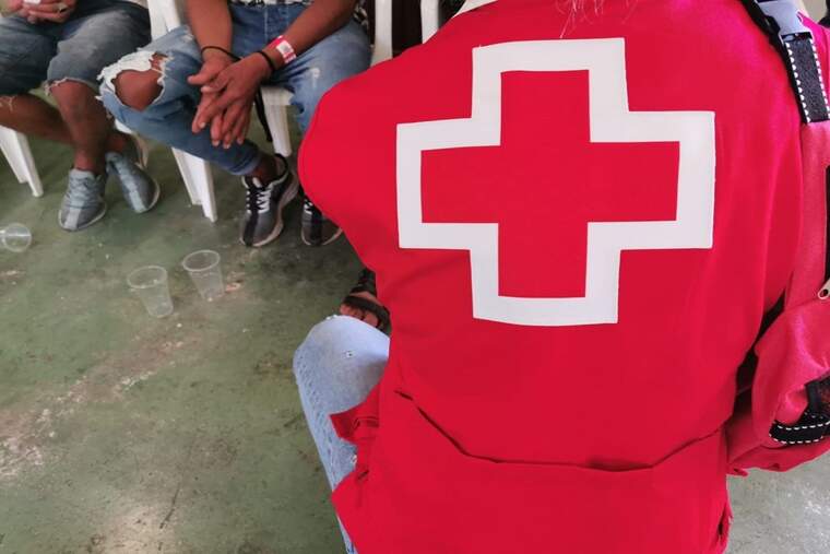 Una persona de Creu Roja ajudant a un immigrant