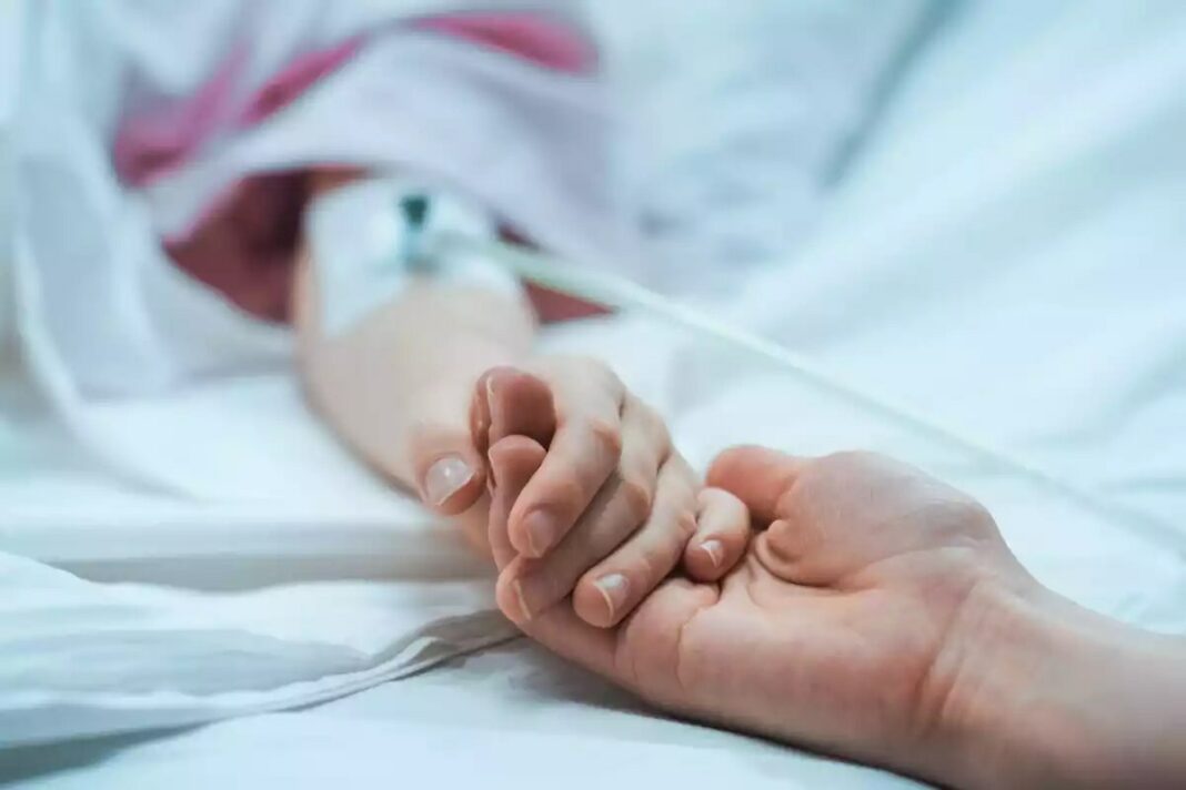 Una mare agafa la mà de la seva filla a un hospital