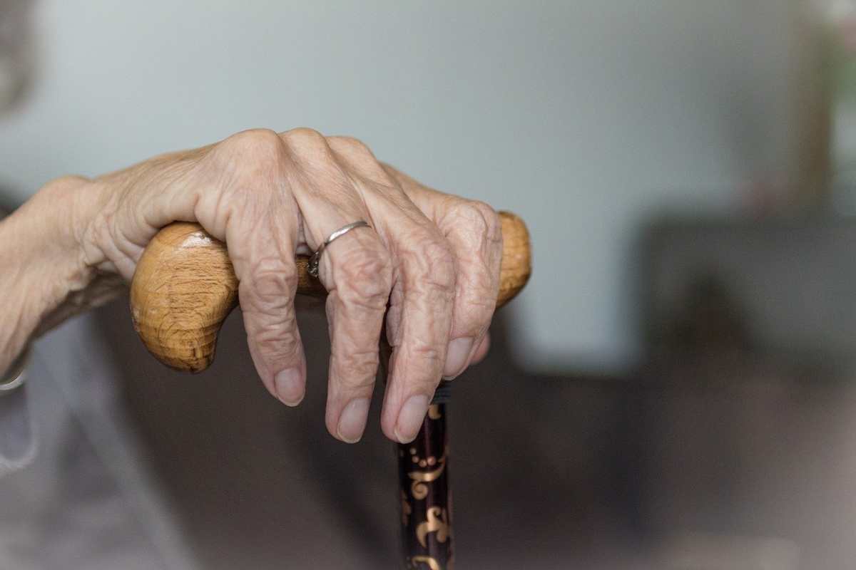 Imatge d'una mà d'una àvia amb un bastó