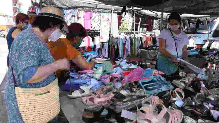 Pla obert de diverses compradores comprant sabates en una de les parades del mercat de Bonavista que ha reobert després de tres mesos d'inactivitat. Imatge de 21 de juny del 2020