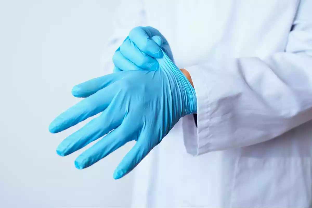 Imatge d'arxiu d'un professional sanitari posant-se uns guants