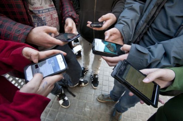 Grup d'adolescents amb telèfons mòbils connectats a les xarxes socials
