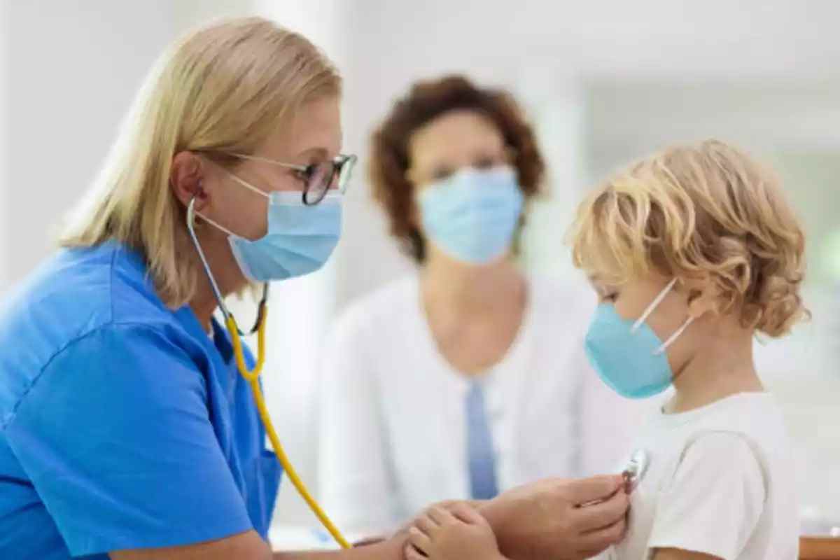 Imatge d'una pediatra amb un nen, els dos amb mascareta