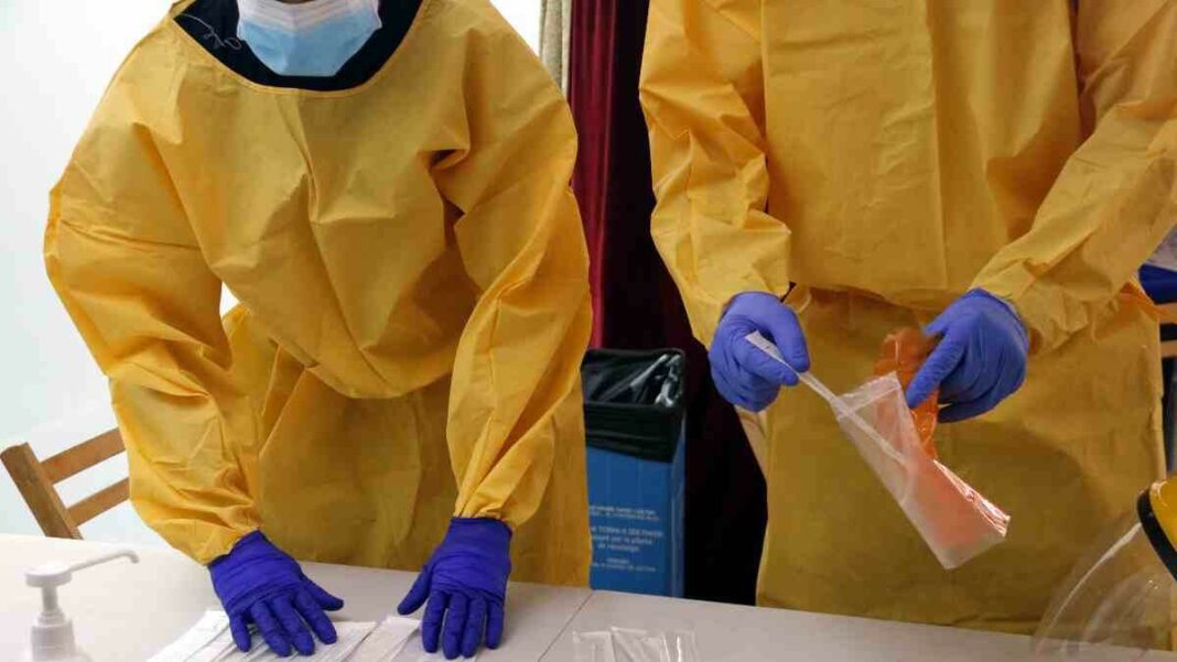 Pla curt on es pot veure a dos sanitaris preparant proves PCR per a un cribratge