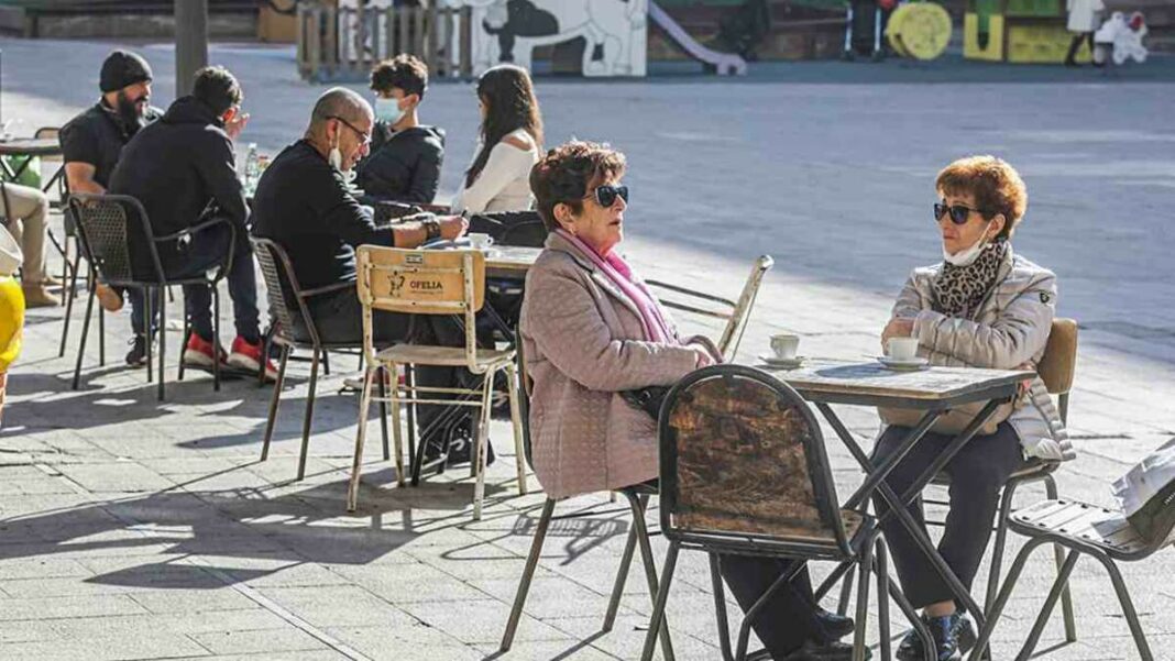 Imatge de diverses persones amb mascareta assegudes a la terrassa d'un bar