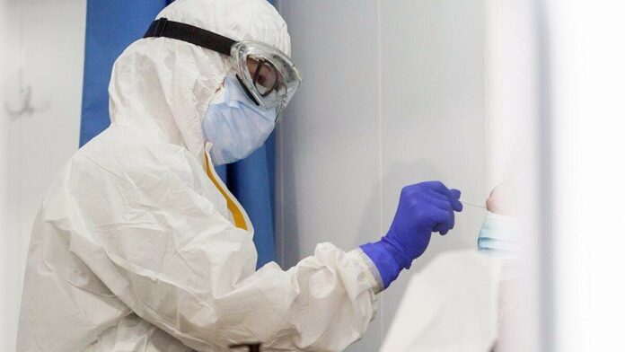 Un professional sanitari duent a terme un test d'antígens a una persona