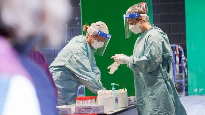 Dues sanitàries preparant el material per realitzar tests d'antígens