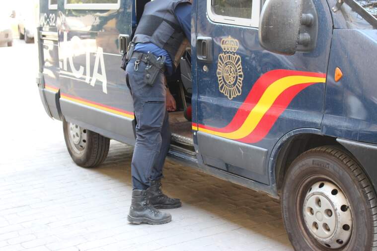 Un agent agafant alguna cosa del furgó de la policia Nacional de València