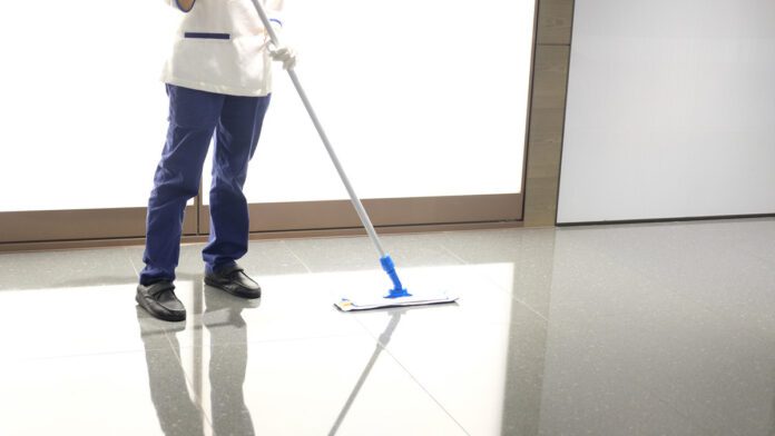 Una treballadora de la neteja amb una mopa Una treballadora de la neteja amb una mopa