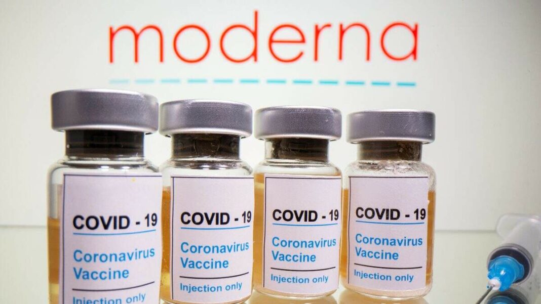 Vials amb un adhesiu que diu «COVID-19 / Vacuna contra el coronavirus / només per injecció» i una xeringa davant del logotip de Moderna