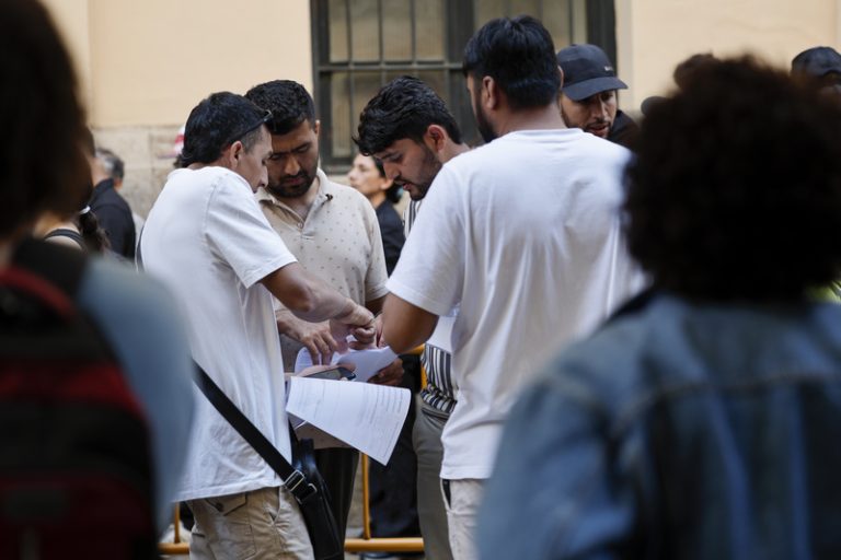 Llargues cues i traves marquen el primer dia presencial de la regularització de migrants a València